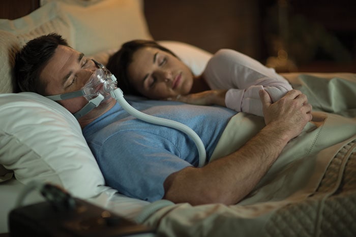 un homme et une femme dormant dans un lit
