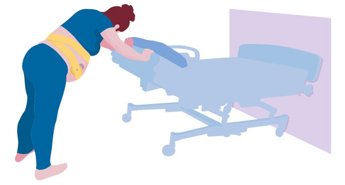 une femme poussant un patient dans un lit d'hôpital