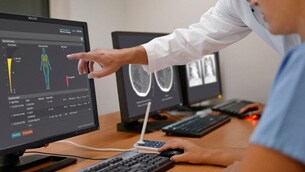 un homme pointant vers un écran d'ordinateur