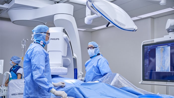 Chirurgiens vasculaires effectuant une intervention chirurgicale avec guidage par l’imagerie