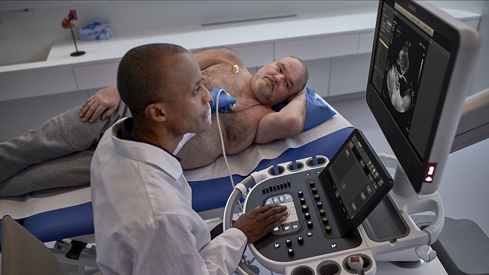 Photo of clinicians conferring about CT results on a computer monitor