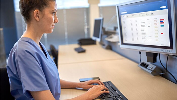 Une clinicienne regarde l’écran en tapant sur le clavier pour saisir des données