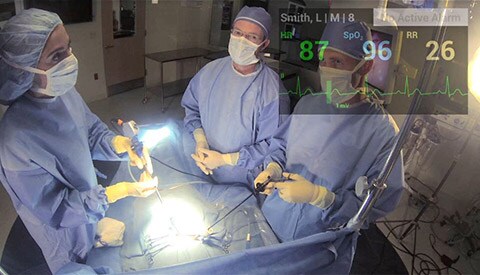 Salle de simulation du bloc opératoire avec les paramètres vitaux affichés dans le coin supérieur des Google Glass.