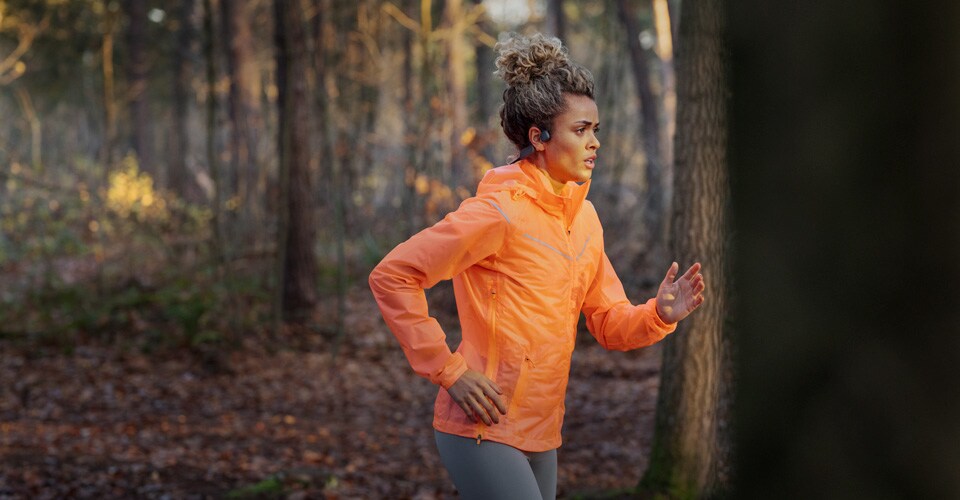 Un athlète utilise des écouteurs sans fil à conduction osseuse pour courir en extérieur