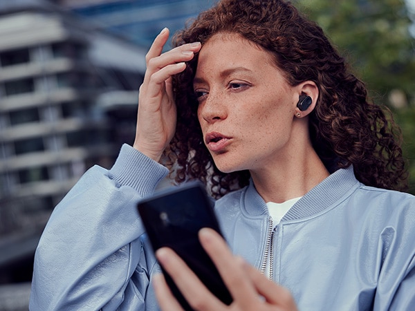 Femme profitant de la fonction d’appel cristallin des écouteurs Philips