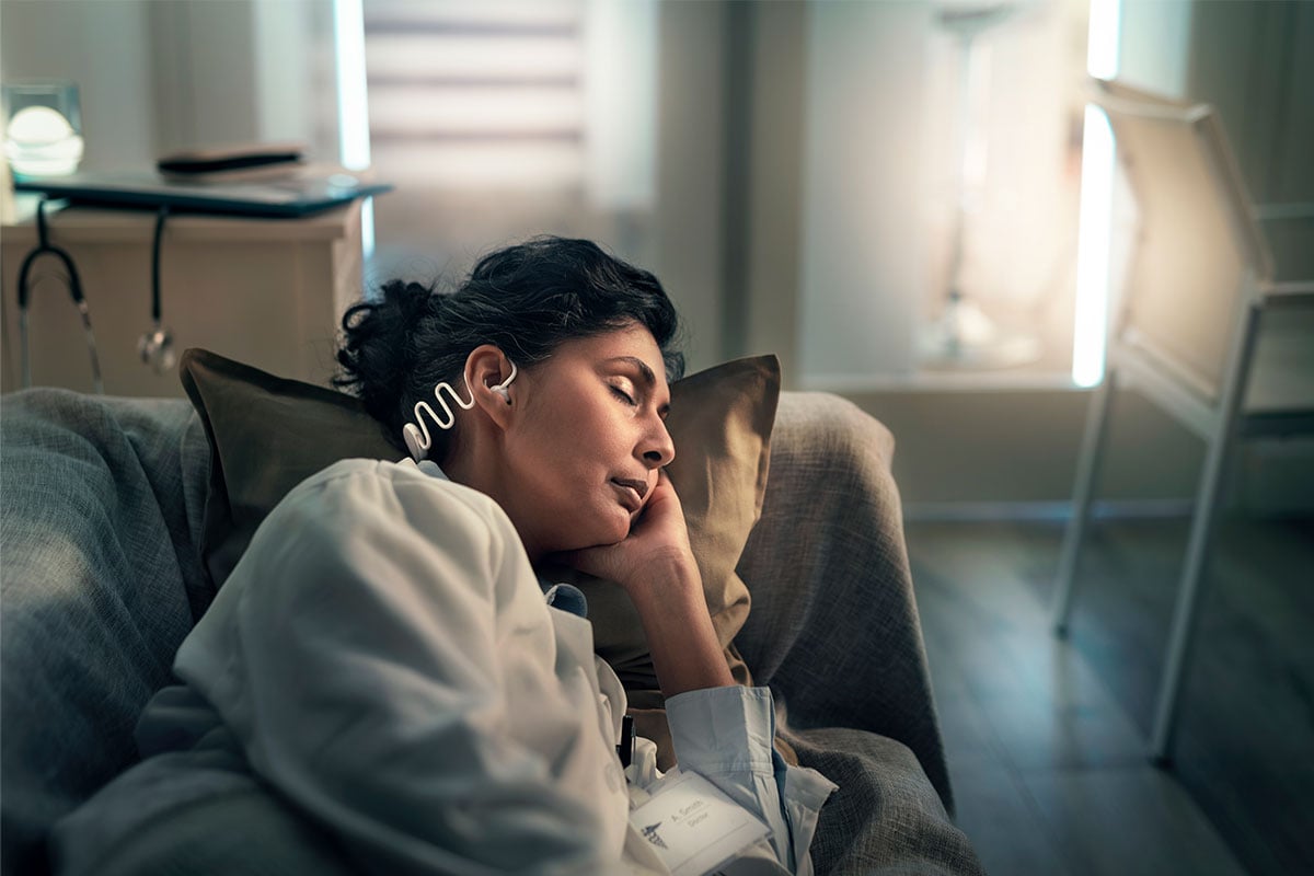 Femme portant confortablement un casque de sommeil Philips en dormant sur le côté.