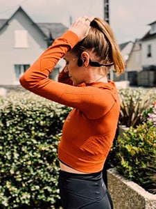 Coureuse montrant un casque à conduction osseuse