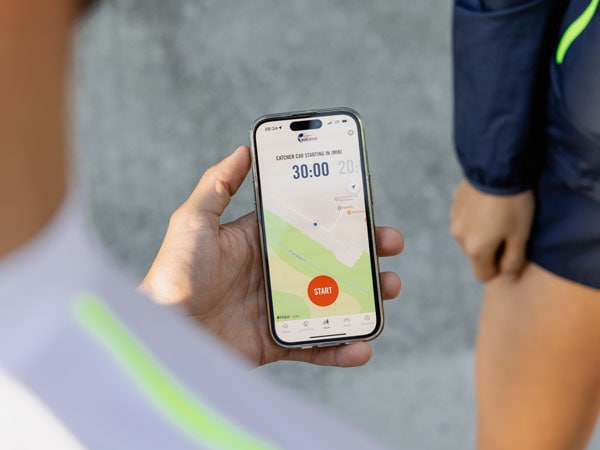 Un participant à la course consulte son téléphone, en attendant le début de la course.