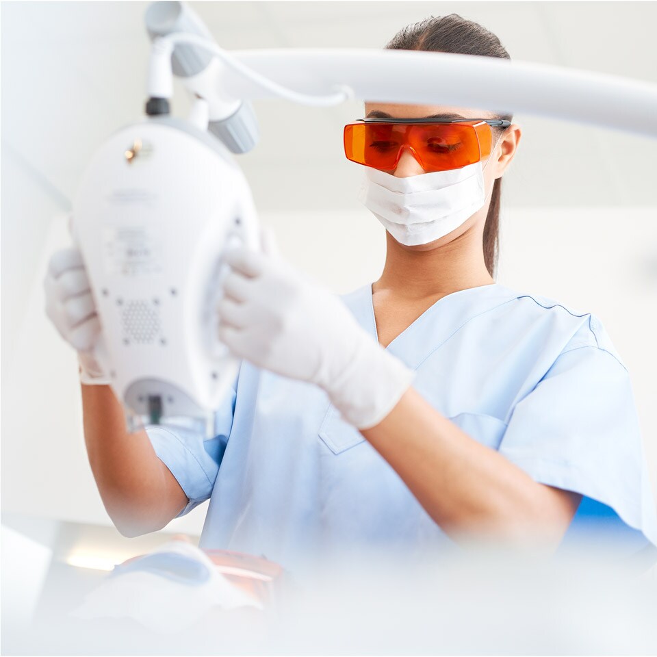 Un professionnel de la santé bucco-dentaire ajustant une lampe Zoom! WhiteSpeed