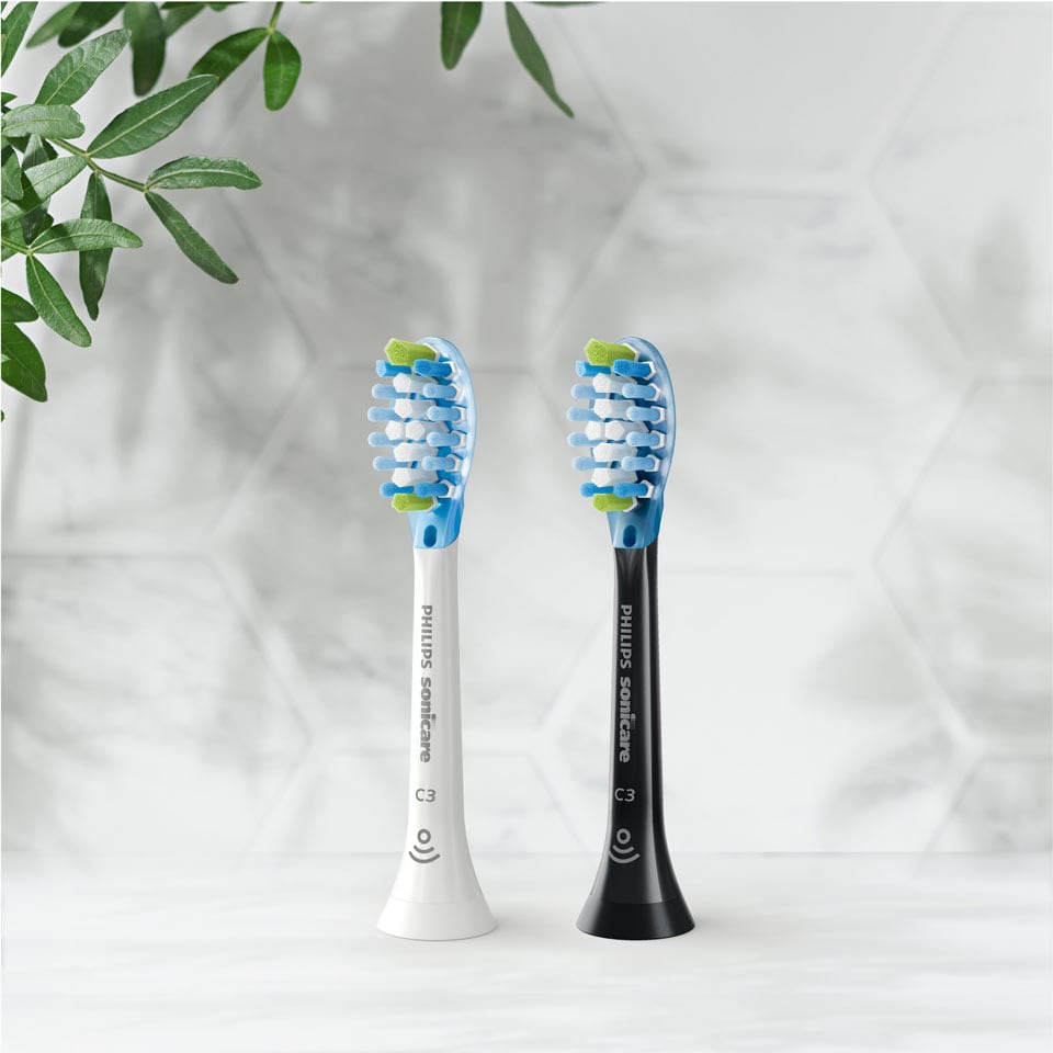 Deux têtes de brosse Premium Plaque Defense posées sur un plan de travail