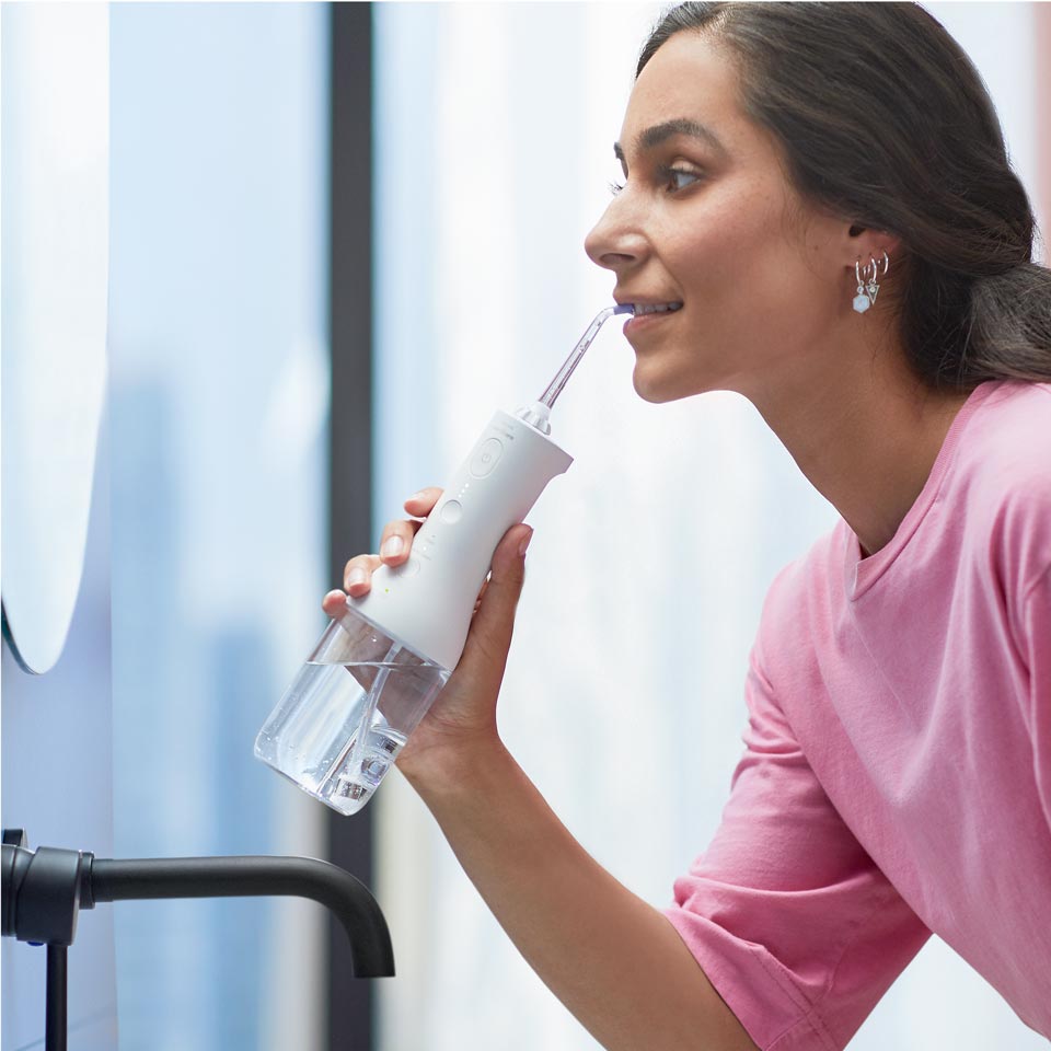 Femme utilisant un Power Flosser sans fil