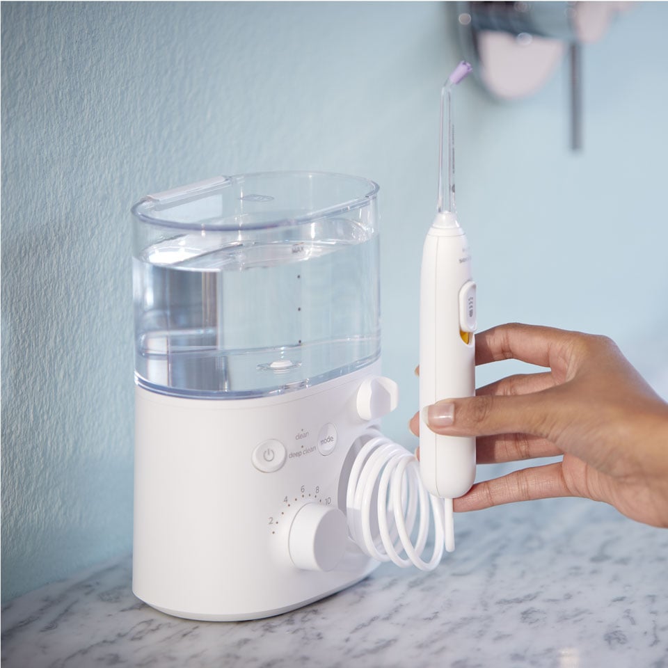 Main saisissant le manche d'un Power Flosser