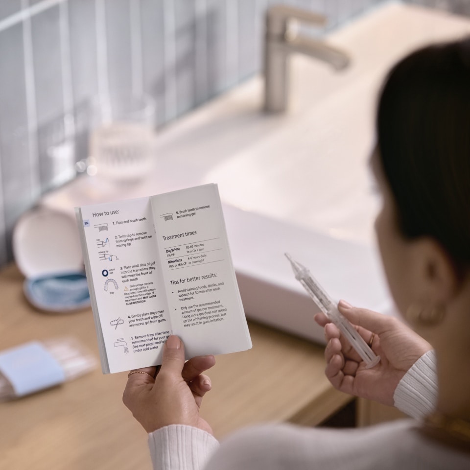 Patient appliquant du gel éclaircissant sur une gouttière sur mesure