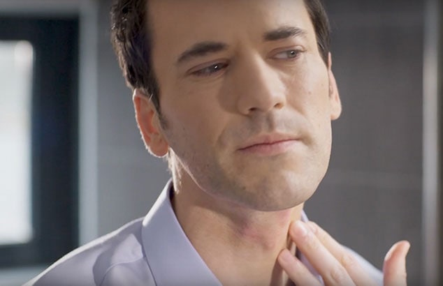 Un homme attrape son cou avec ses doigts et vérifie si sa peau a des boutons.