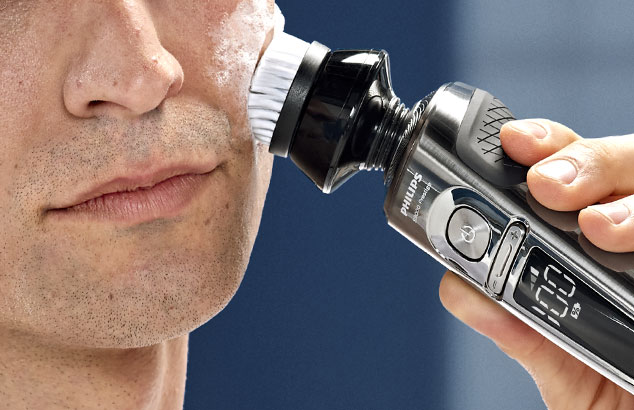 Gros plan d'un homme en train de s'exfolier le visage avec la tête d'exfoliation du rasoir Philips S9000 Prestige.