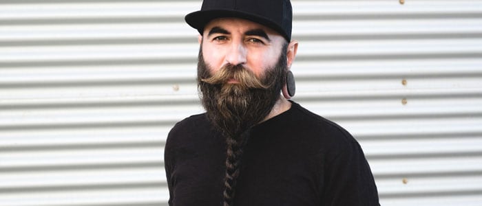 Un homme porte une barbe hipster avec une moustache et une tresse au niveau du menton.
