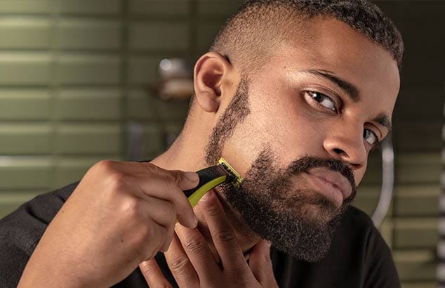 Image d’un homme en train de se tailler une barbe Henriquatre.