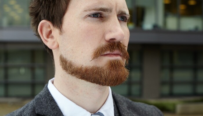 Gros plan d’un homme avec une barbe Balbo méticuleusement taillée.