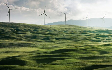 Centrale éolienne sur des collines, symbolisant les énergies renouvelables et le développement durable en entreprise.