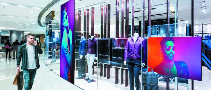 Affichage numérique dynamique - mur vidéo LED | homme marchant dans un magasin