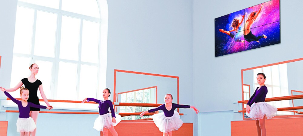 Écran d'affichage numérique au mur - enfants s'exerçant à la danse classique dans une pièce